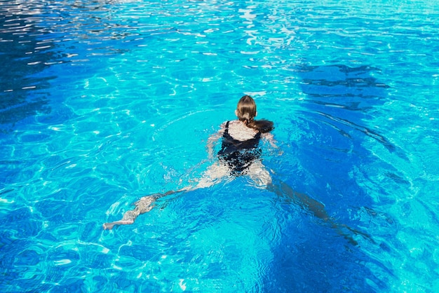 Junge Frau schwimmt auf dem Wasser im Schwimmbad