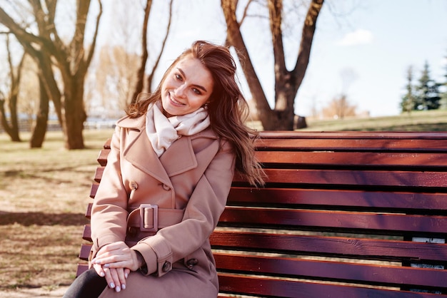 Junge Frau sitzt auf der Bank im Park
