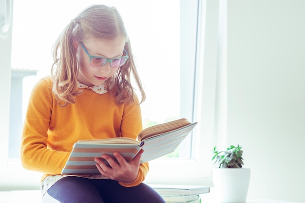 Foto junge frau sitzt auf einem buch