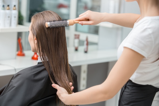 Junge Frau sitzt im Friseursalon Frisur Styling nass