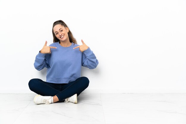 Junge Frau sitzt stolz und selbstzufrieden auf dem Boden floor