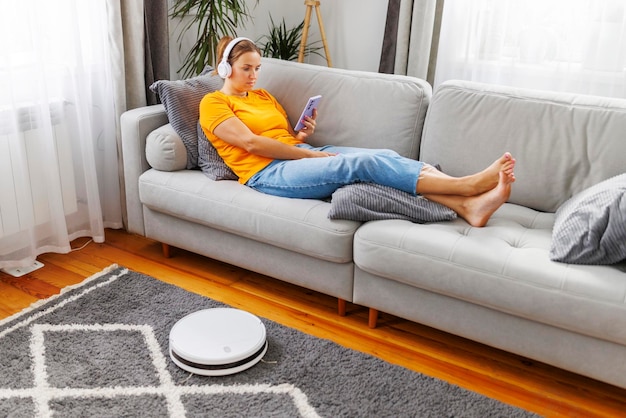 Junge Frau sitzt zu Hause auf dem Sofa