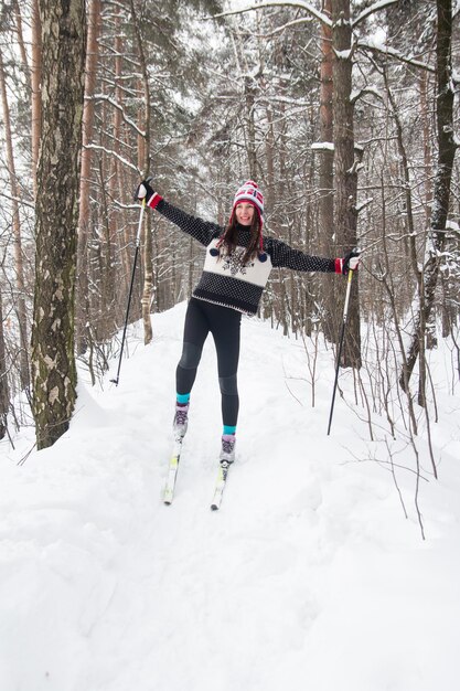 Junge Frau Skifahren im Park Weißer Winterwald und Skifahrer