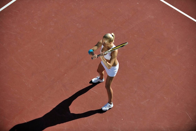 junge Frau spielt im Freien Tennis