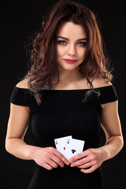 Junge Frau spielt im Glücksspiel auf schwarzem Hintergrund
