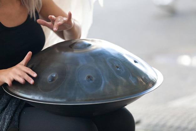 Junge Frau spielt mit einer Handpan