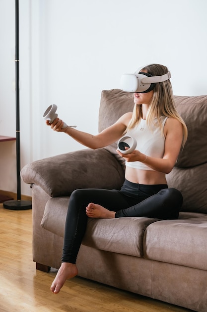 Junge Frau spielt Virtual-Reality-Spiele vom Sofa aus