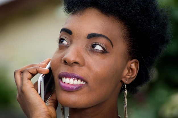 Junge Frau spricht am Telefon und blickt ab