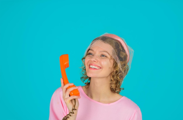 Junge Frau spricht über Retro-Telefon lächelnde Frau im rosa Kleid mit Telefonhörer glückliche Frau