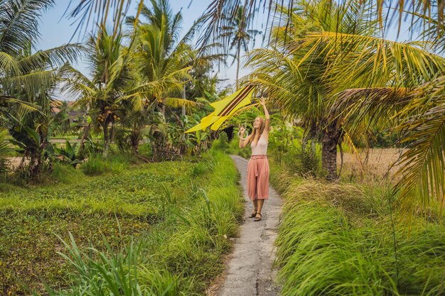 Junge Frau startet einen Drachen in einem Reisfeld in Ubud, Insel Bali, Indonesien