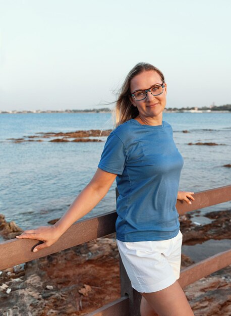 Foto junge frau steht am strand