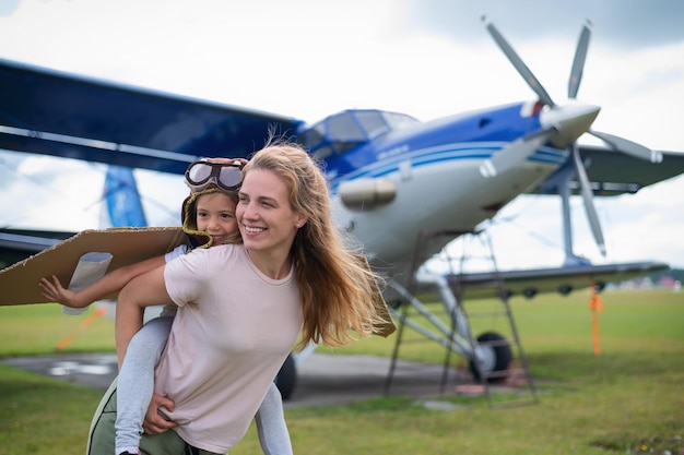 Foto junge frau steht neben einem flugzeug auf der start- und landebahn