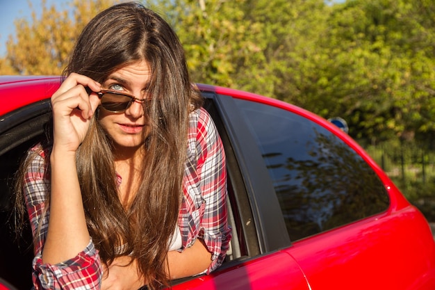 Junge Frau steigt aus Autofenster