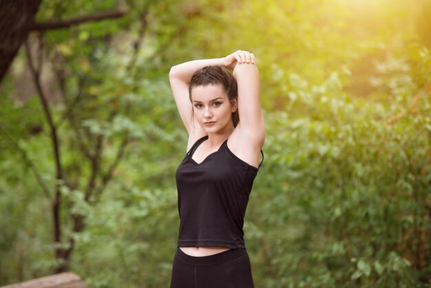 Junge Frau Stretching vor dem Laufen in bewaldeten Waldgebiet Training und Training für Trail Run Marathon Ausdauer Fitness gesunden Lebensstil Konzept