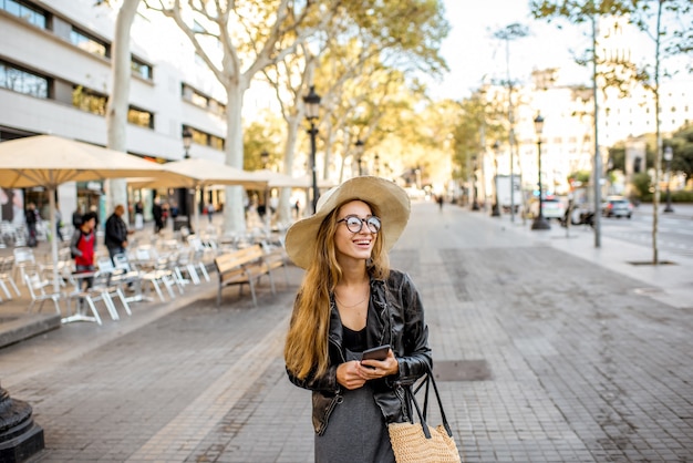 Junge Frau Tourist mit Hut zu Fuß auf der berühmten Fußgängerzone in Barcelona City