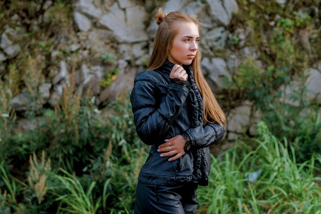 Foto junge frau trägt schwarze warme kleidung gegen felsbildung