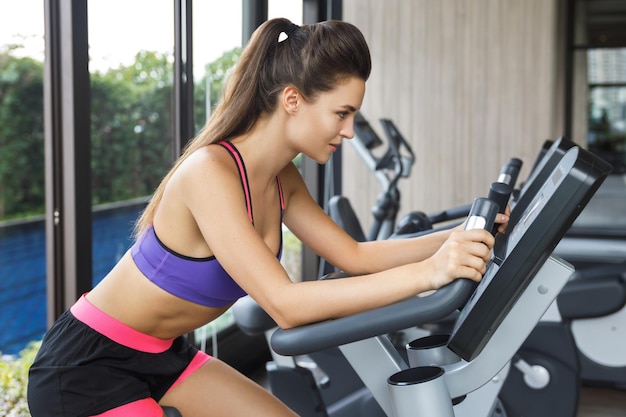 Junge Frau trainiert im Fitnessstudio