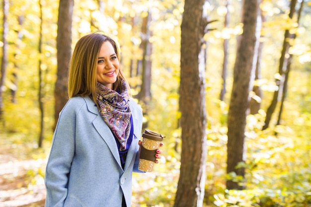 junge Frau trinken Kaffee im Herbstpark