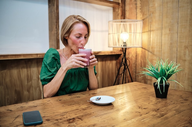 Junge Frau trinkt gesunden Smoothie