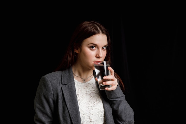 Junge Frau trinkt reines sauberes Wasser aus dem Glas