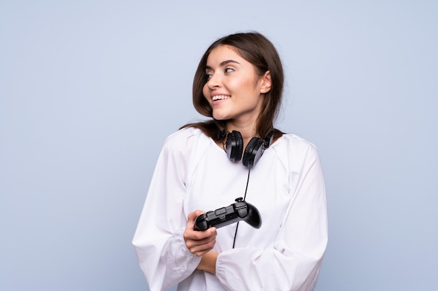 Junge Frau über dem lokalisierten blauen Hintergrund, der an den Videospielen spielt