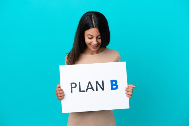 Junge Frau über isoliertem Hintergrund mit einem Plakat mit der Nachricht PLAN B