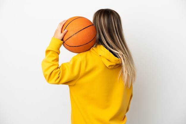 Junge Frau über isoliertem weißem Hintergrund Basketball in Rückenlage spielen playing