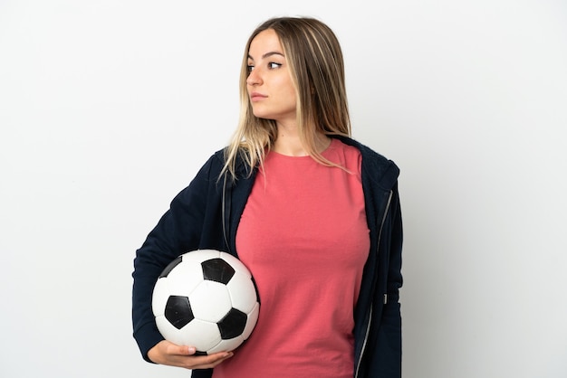 Junge Frau über isoliertem weißem Hintergrund mit Fußball