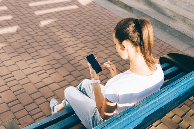 Junge Frau überprüft ihr intelligentes Telefon