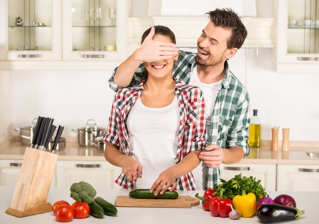Junge Frau und Ehemann kochen mit Frischgemüse.