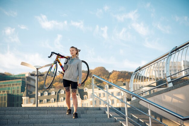 Junge Frau und Fahrrad in der Stadt