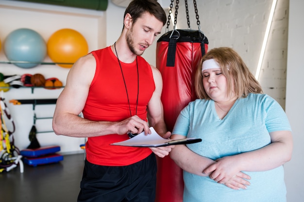 Junge Frau und ihr Trainer sprechen