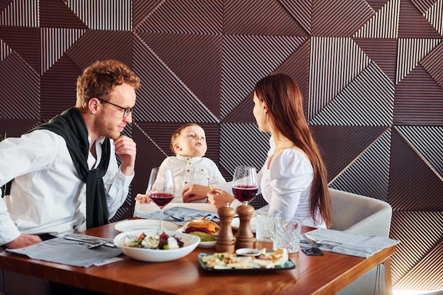 Junge Frau und kleiner Junge im Innenbereich des neuen modernen Luxusrestaurants