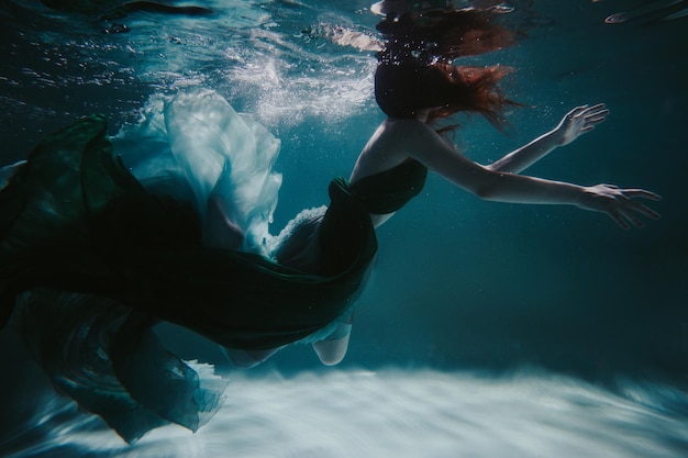 Junge Frau unter Wasser in einem schönen Kleid unter Wasser schießen