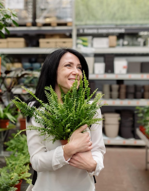 Junge Frau wählt Zimmerpflanzen in einem Blumenladen