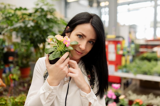 Junge Frau wählt Zimmerpflanzen in einem Blumenladen