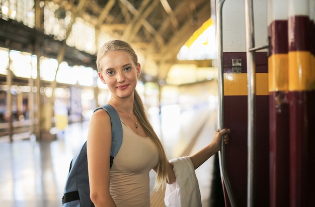 Junge Frau wartet im Oldtimerzug, entspannt und unbeschwert am Bahnsteig