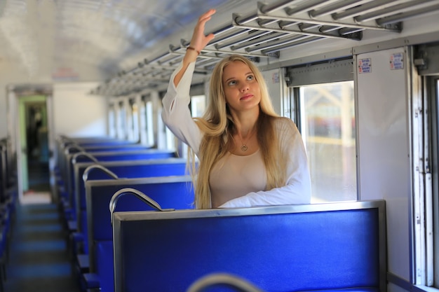 Junge Frau wartet im Oldtimerzug, entspannt und unbeschwert am Bahnsteig