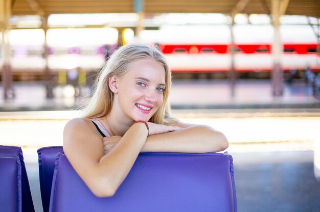 Junge Frau wartet im Oldtimerzug, entspannt und unbeschwert am Bahnsteig