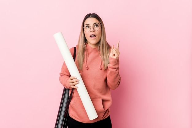 Junge Frau, welche die Architektur zeigt Oberseite mit geöffnetem Mund studiert.