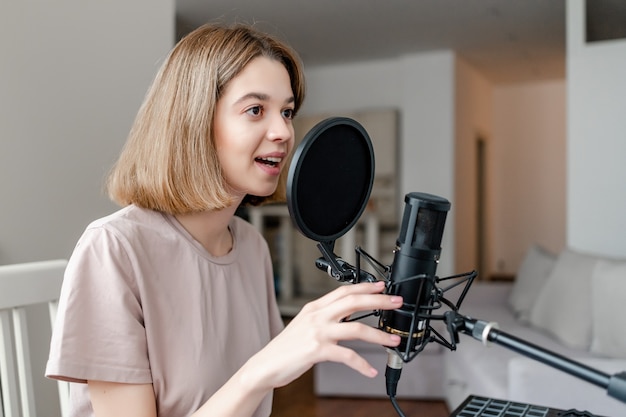 Junge Frau zeichnet auf, wie sie zu Hause singt