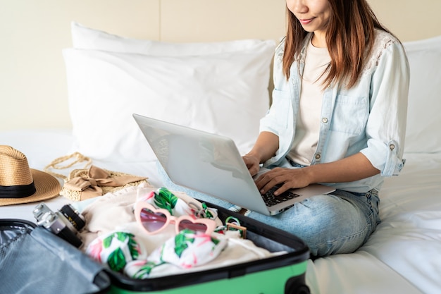 Junge Frauen, die eine Sommerurlaubsreise planen und Informationen suchen oder ein Hotel auf dem Laptop buchen, Reisekonzept