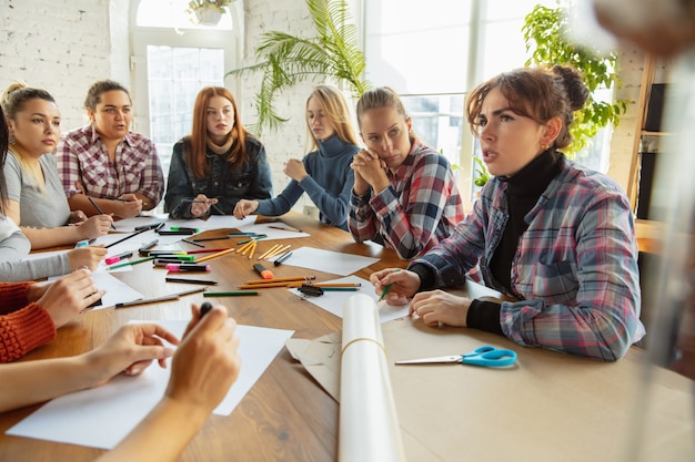 Foto junge frauen, die im büro poster über frauenrechte und gleichberechtigung vorbereiten