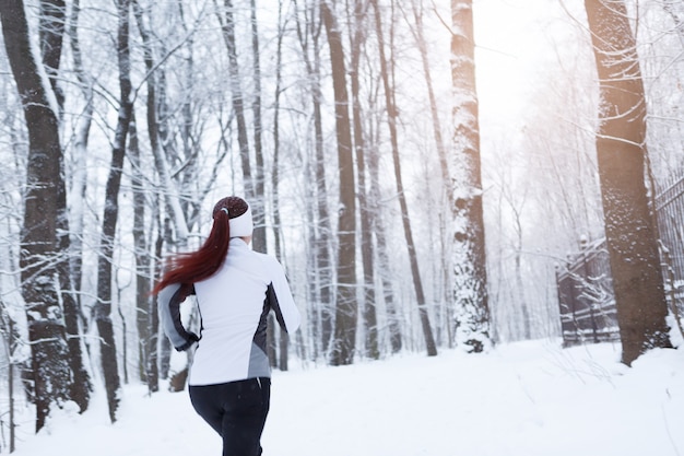 Junge Frauen, die im Winterwald laufen