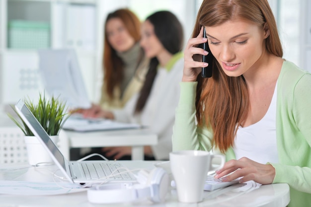 Foto junge frauen, die mit modernen geräten im büro arbeiten