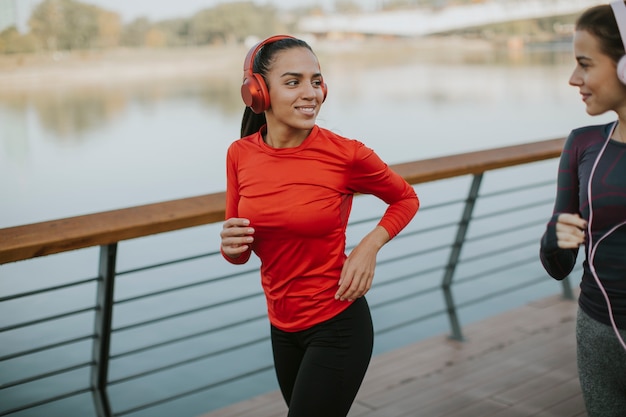 Junge Frauen, die morgens durch den Fluss laufen