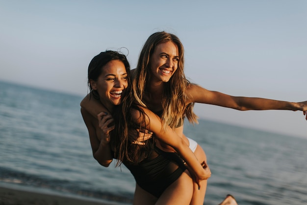 Junge Frauen, die Spaß an den Sommerferien am Strand haben