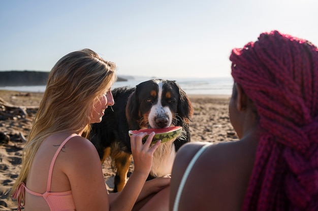 Foto junge frauen haben spaß mit hund am strand