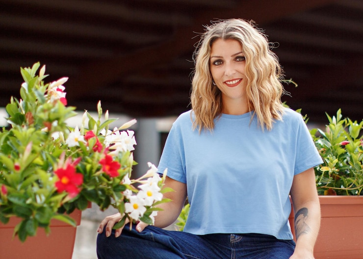 Foto junge frauen in t-shirts und jeans sitzen zwischen blumen