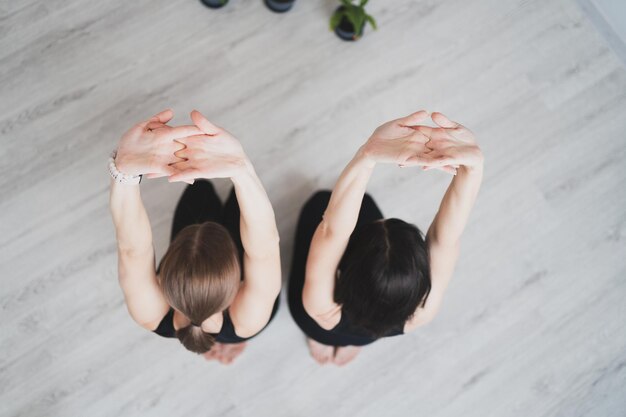 Junge Frauen sitzen auf Yogamatten, um mit Meditation und Yoga zu beginnen